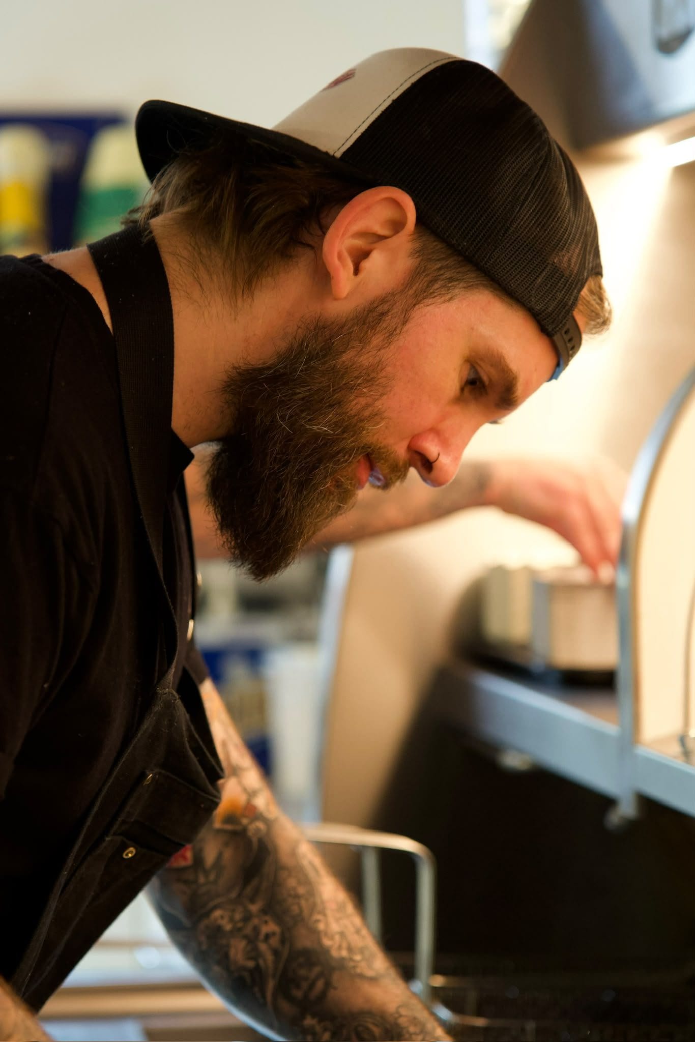 L’autre patron, de profil, penché sur le comptoir.